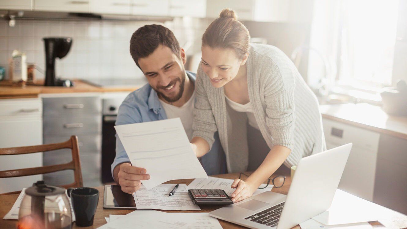 Paar schaut sich Rechnungen am Küchentisch an