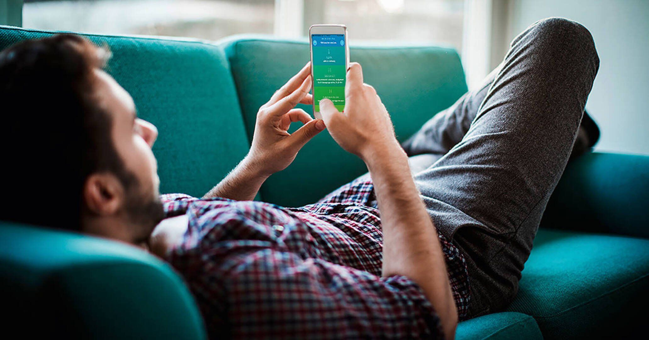 Mann mit Handy auf der Couch