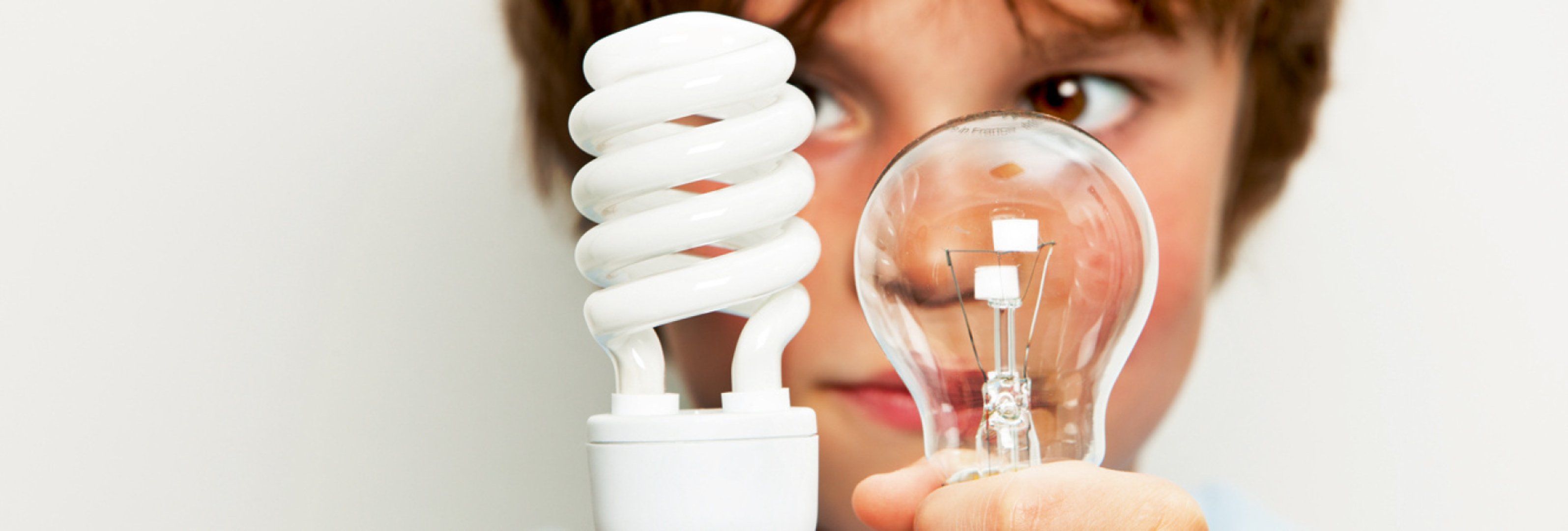 Kind vergleicht Glühbirnen