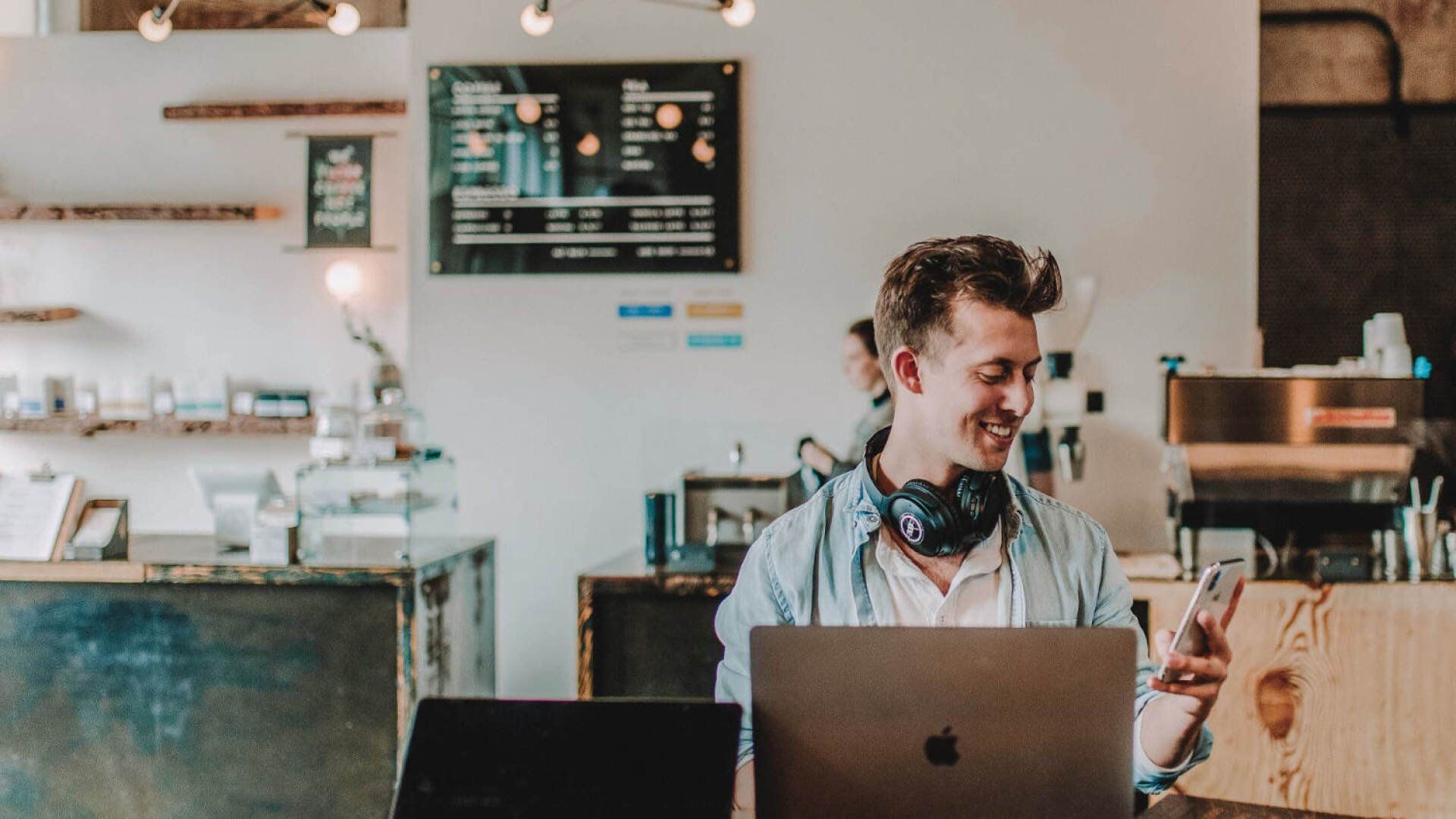 Es ist ein Mann zu sehen, der im Home Office an seinem Schreibtisch sitzt und einen Artikel über Tipps im Home Office liest.