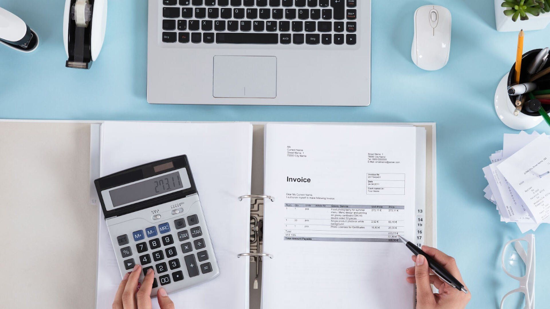 Auf einem Tisch liegt ein Ordner mit Rechnungen und ein Taschenrechner, mit dem die Kosten für den Strom für die Infrarotheizung ausgerechnet werden.