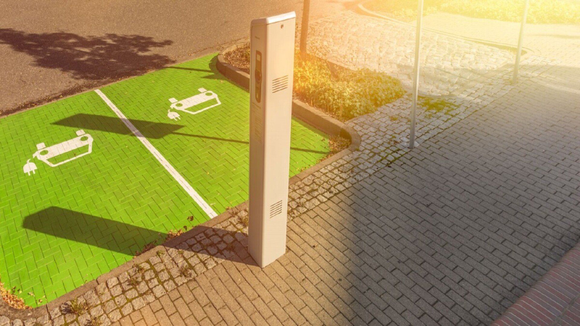 Auf dem Bild steht eine E-Ladesäule auf zwei grün markierten E-Auto-Parkplätzen.
