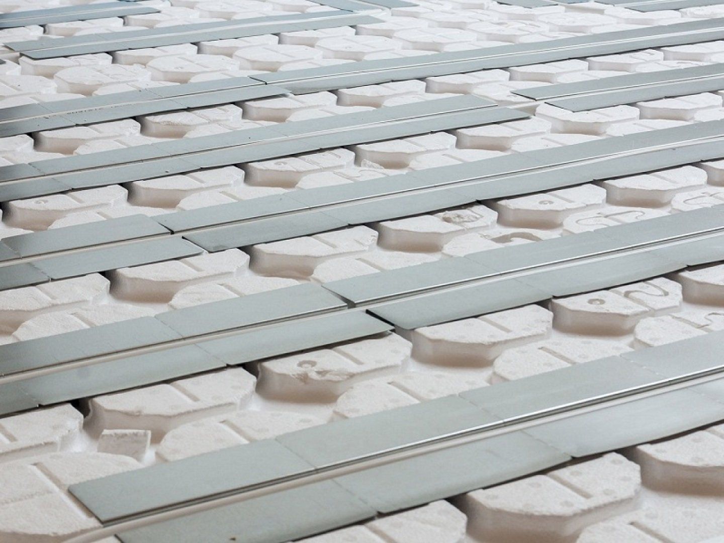 Zu sehen sind die Systemplatten und Rohre einer Fußbodenheizung als Trockensystem.