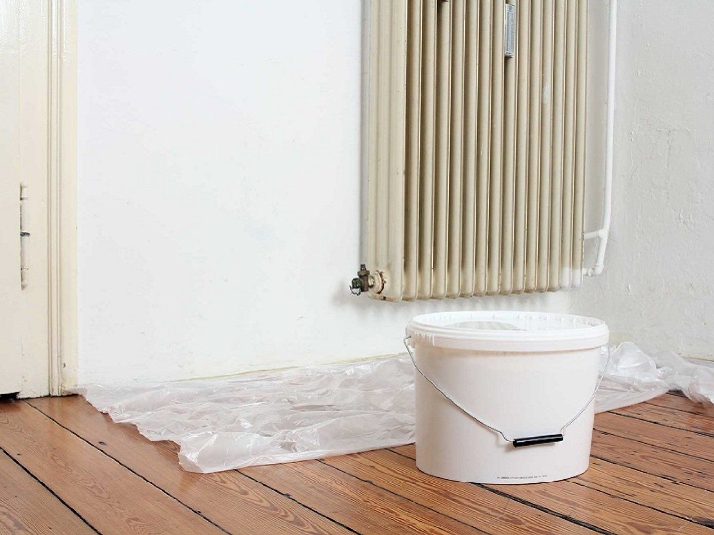 Materialien zum Streichen eines Heizkörpers stehen bereit.