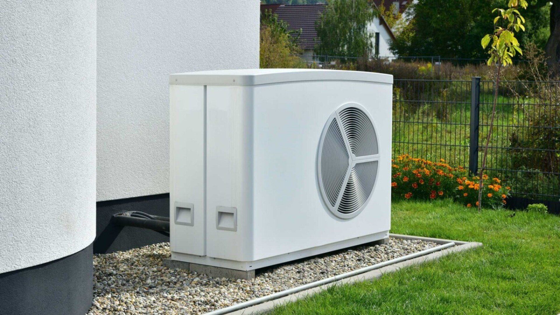 Das Bild zeigt eine Wärmepumpe vor einem Haus.