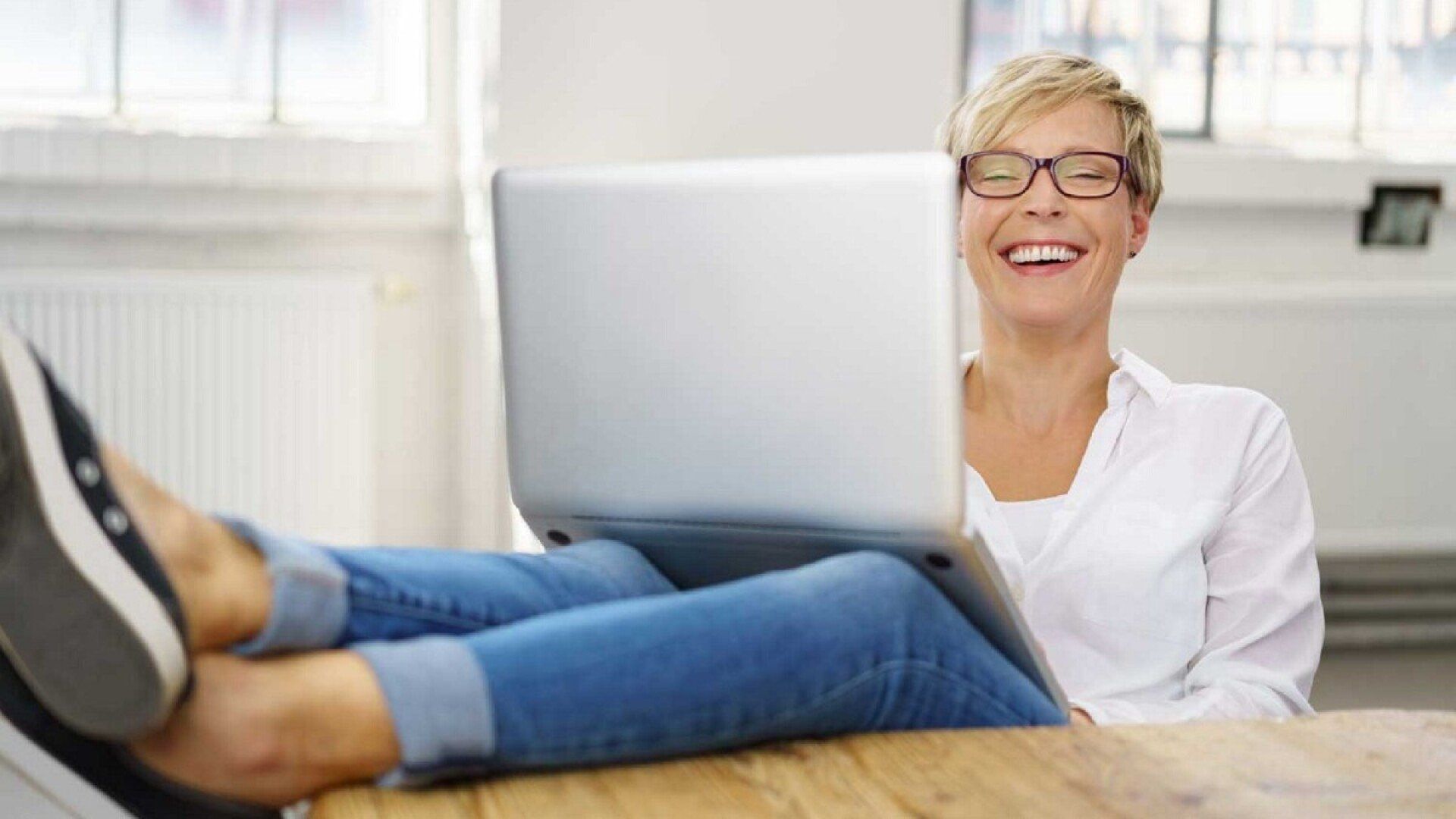 Eine Frau freut sich über die Vorteile des Glasfaser-Internets.