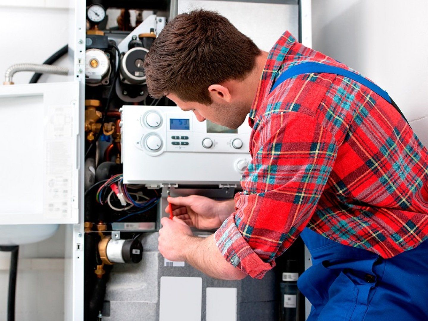 Ein Mann führt einen hydraulischen Abgleich der Heizung durch.