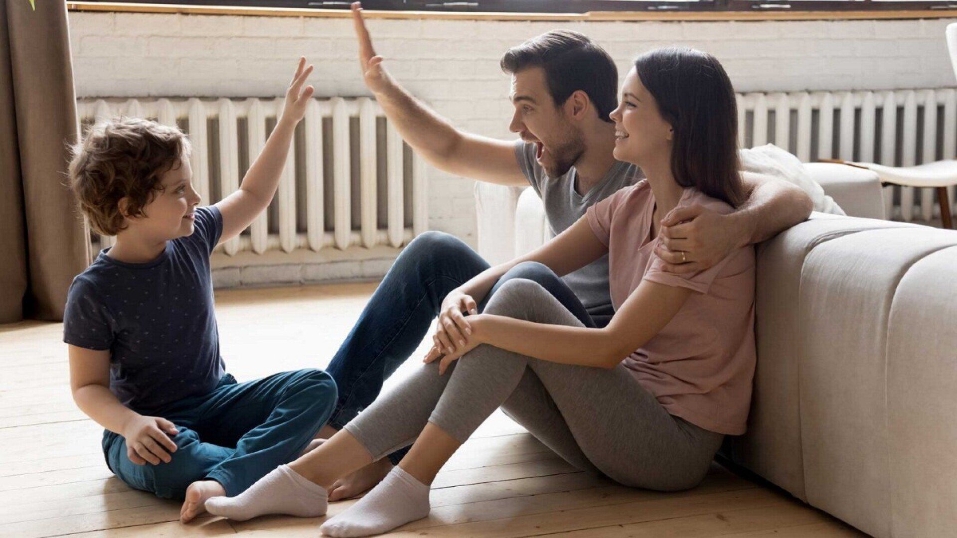 Eine Familie sitzt auf warmem Fußboden nach dem Umbau der Ölheizung auf Wärmepumpe und den geförderten Kosten.