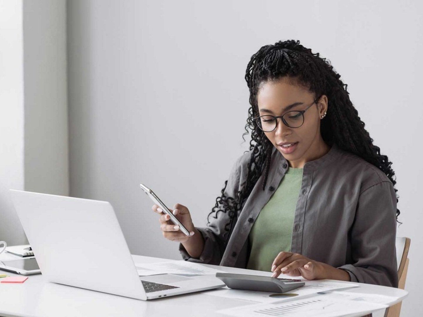 Eine Frau berechnet Stromkosten anhand des Arbeitspreises für Strom und des Verbrauchs.