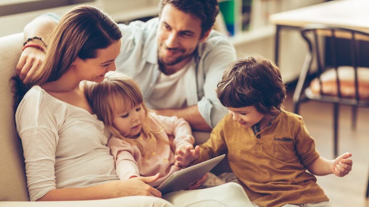 Familie Mutter Vater Kind auf Sofa mit Tablet
