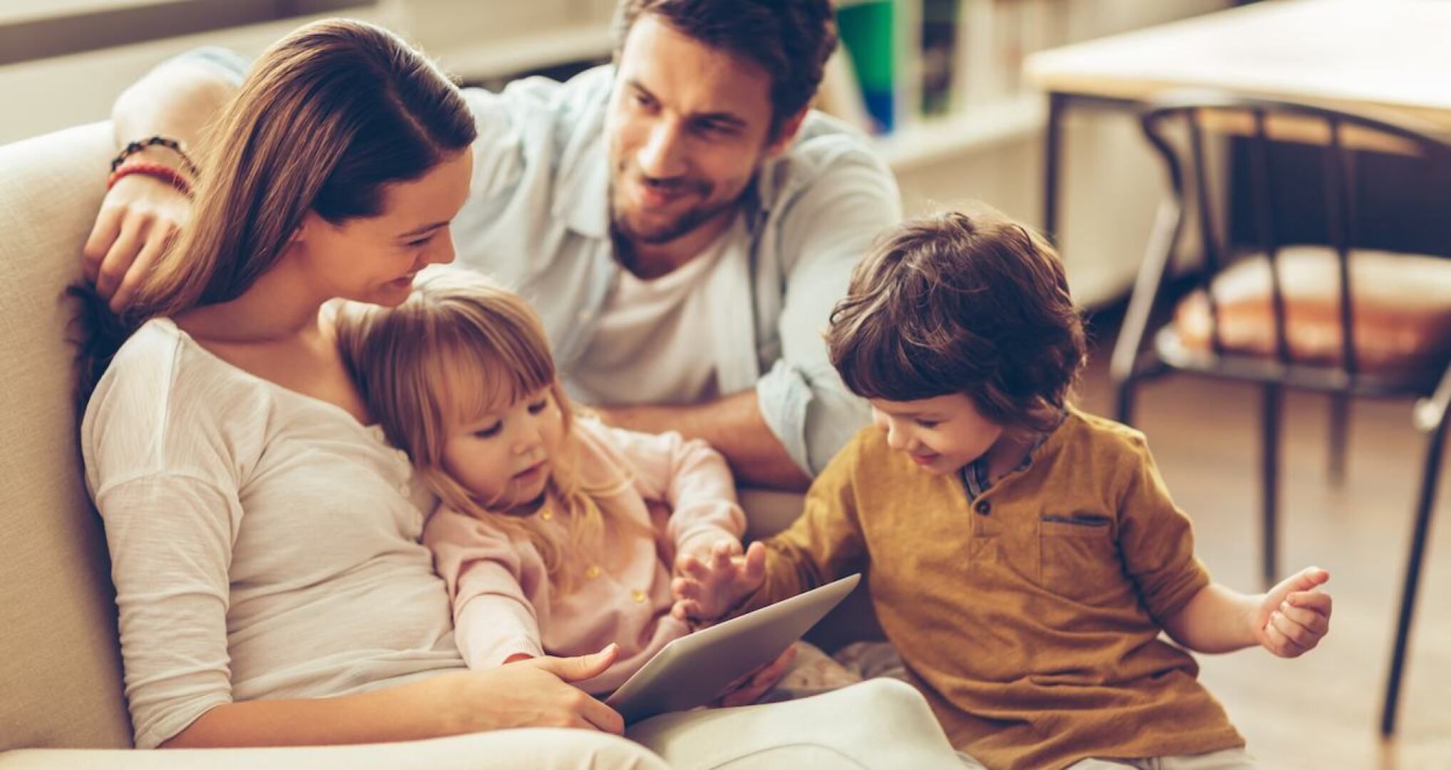 Familie Mutter Vater Kind auf Sofa mit Tablet