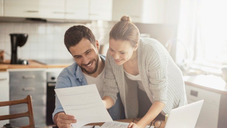 Paar berechnet Rechnung mit Taschenrechner