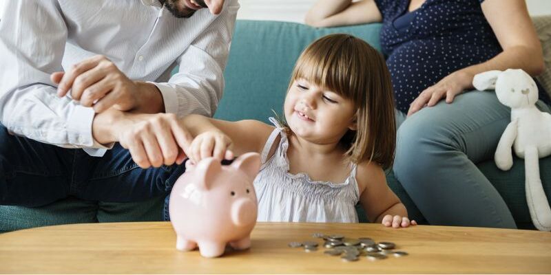Familie wirft Geld in Sparschwein
