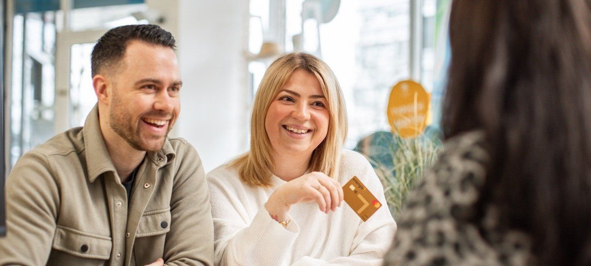 Paar bei Buchung im Reisebüro mit der energis Mastercard GOLD