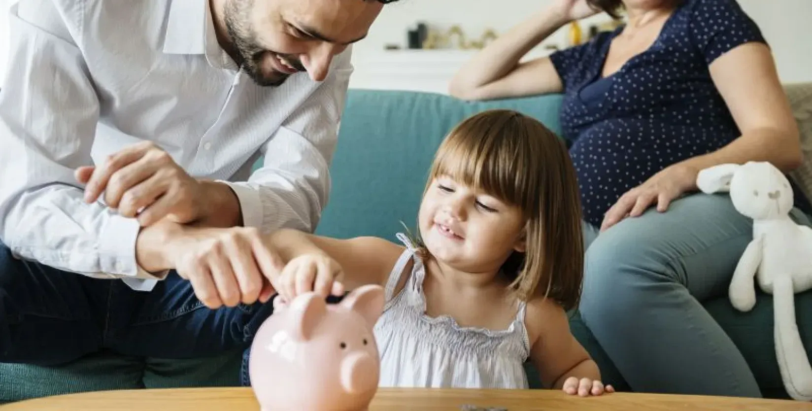 Familie wirft Geld in Sparschwein