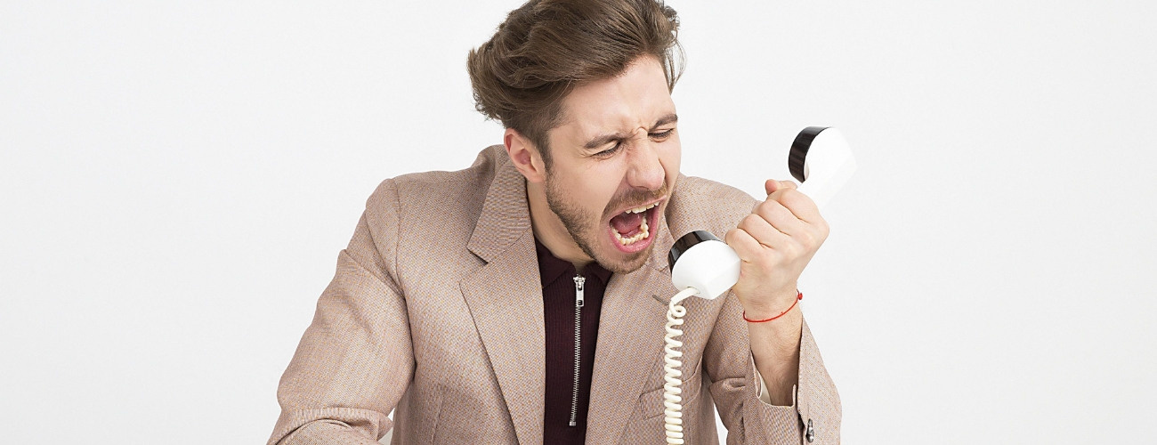 Ein verärgerter Mann ist unzufrieden mit seinem bisherigen Anbieter und möchte daher den Telefonanbieter wechseln