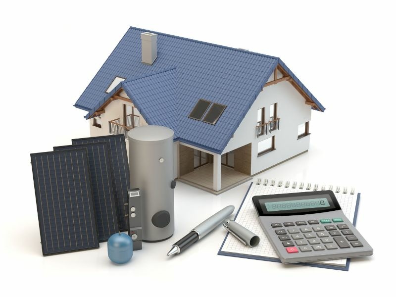 Die Grafik zeigt ein Haus, Solarpanels und Zubehör. Daneben liegen ein Block, ein Taschenrechner und ein Stift. 