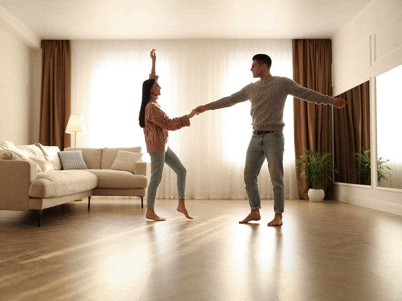 Ein Paar tanzt barfuß, da der Boden durch eine Fußbodenheizung beheizt ist.