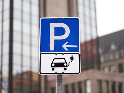Ein Verkehrszeichen zeigt die Möglichkeit an einer Ladesäule zu parken an.